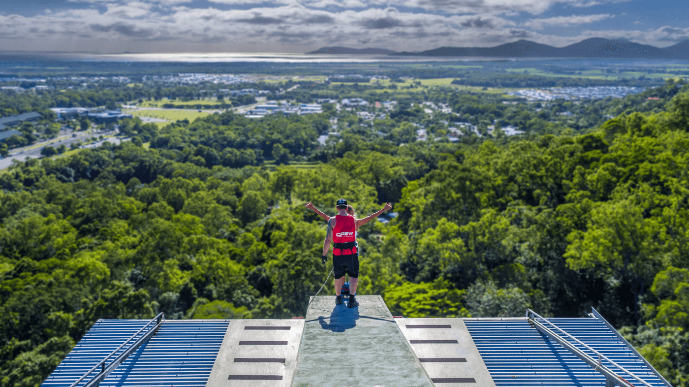 Crew member assisting a jumper at Skypark Cairns tower.