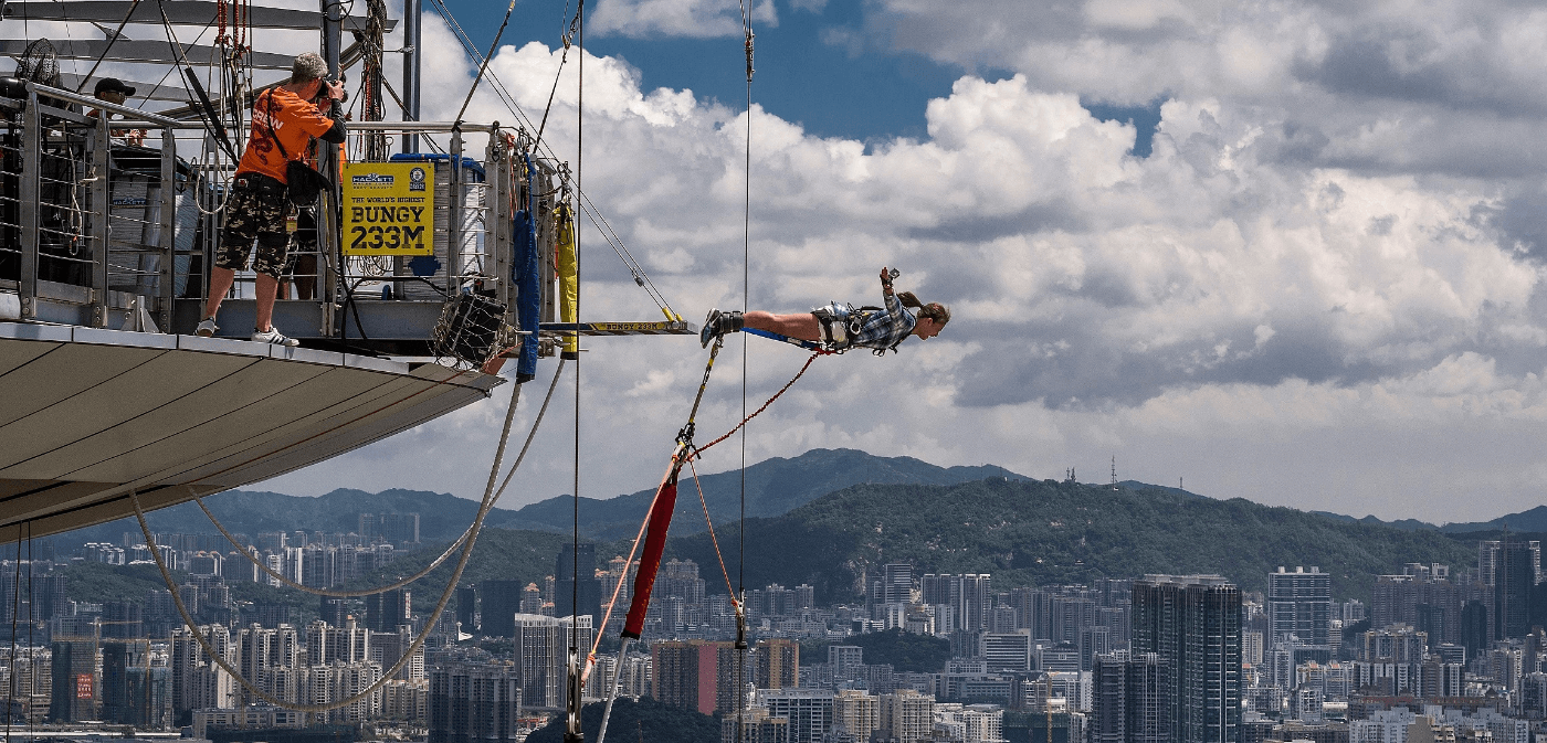 Person mid-air during a bungy jump from the Macau Skypark tower.